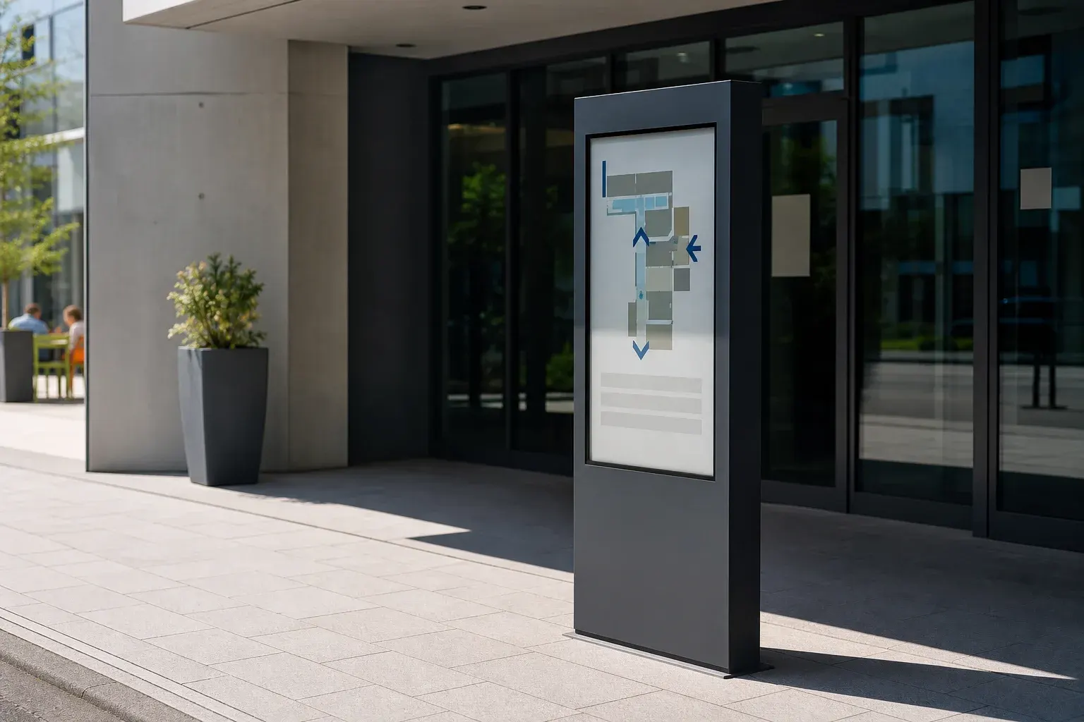 Freistehende Stele mit Lageplan vor dem Glaseingang eines Gebäudes in der Sonne